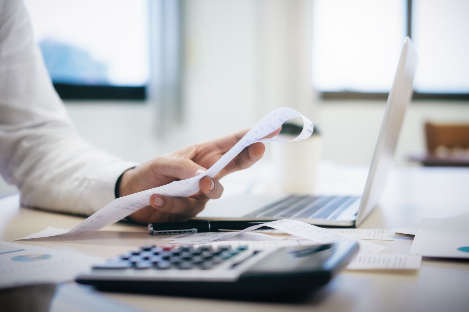 Análise de faturas com calculadora e computador portátil